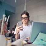 Emplifi Reveals Insights on Influencers and Sponsored Posts to Support Brands’ Social Marketing Strategies woman in white shirt using smartphone